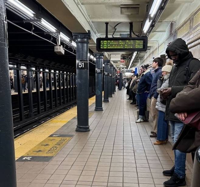 미국 뉴욕 한 지하철에서 시민들이 등을 벽에 기댄 채 열차를 기다리고 있다. /사진=SNS 갈무리