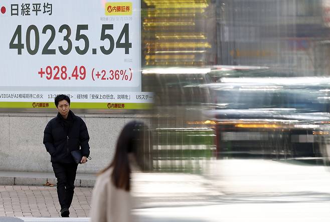 7일 일본 도쿄의 주식 시장 표시판 앞을 지나가는 행인들이 걷고 있다. [EPA]