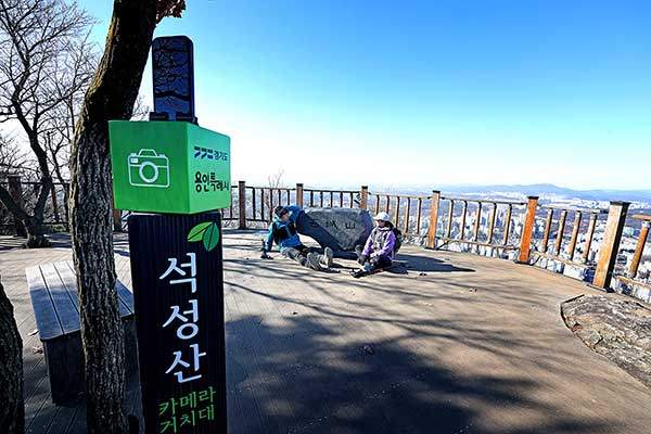 석성산 정상의 전망데크와 정상 표지석. 셀프 카메라 촬영을 위해 스마트폰 거치대를 설치해 놓았다.&nbsp;