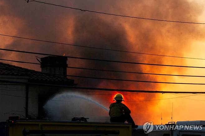 LA 퍼시픽 팰리세이즈 화재 지역에서 진화 중인 소방관 [로이터=연합뉴스. 재판매 및 DB 금지]