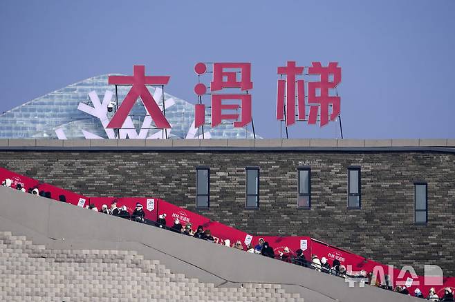 [하얼빈=AP/뉴시스] 6일 중국 헤이룽장성 하얼빈에서 열린 제41회 하얼빈 빙설제에서 관광객들이 얼음 미끄럼틀을 타기 위해 줄을 서고 있다. 2025.01.10.