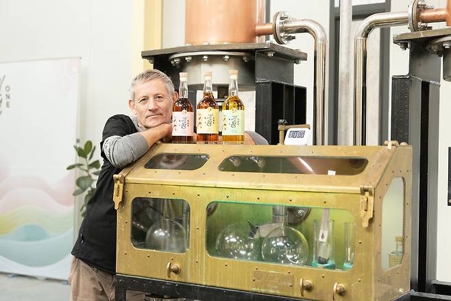Andrew Shand poses with whisky products at his company's distillery. (Ki One Whisky Distillery)