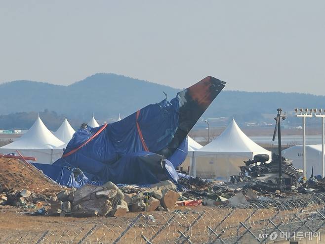 (무안=뉴스1) 전원 기자 = 12일 오전 무안국제공항 활주로 인근에는 제주항공 여객기 동체가 천에 쌓여 있다.2025.1.12/뉴스1  Copyright (C) 뉴스1. All rights reserved. 무단 전재 및 재배포,  AI학습 이용 금지.