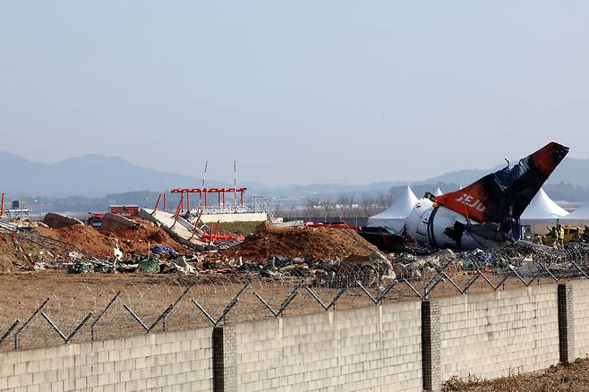 제주항공 여객기 참사 16일째인 13일 오전 무안국제공항 사고 현장에서 소방대원들이 방수포를 걷어내고 있다. [연합]