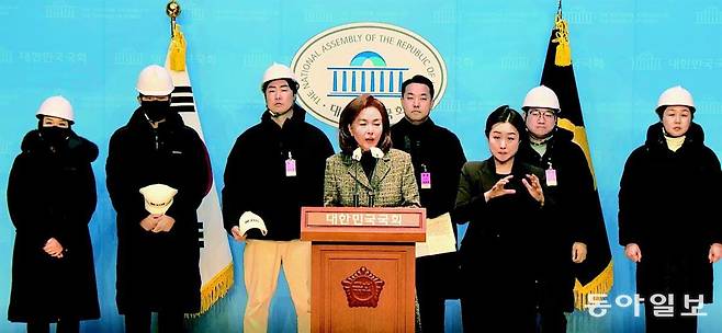 국민의힘 김민전 의원(맨 앞)이 1월 9일 오후 국회 소통관에서 자칭 ‘백골단’이라는 ‘반공청년단’의 기자회견을 열어준 모습. 김 의원 뒤로 하얀색 헬멧을 쓴 청년들이 서 있다. 송은석 기자 silverstone@donga.com