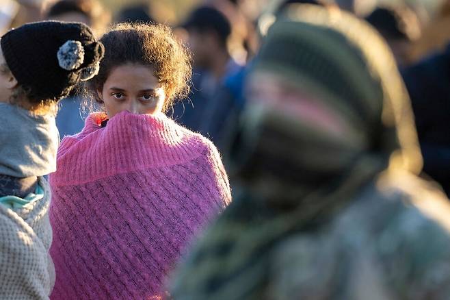 2023년 12월18일 베네수엘라 출신의 한 이민자가 멕시코에서 리오그란데강을 건너 텍사스주 이글 패스에 도착한 뒤 텍사스 주 방위군 병사를 바라보고 있다. 이글 패스/AFP 연합뉴스