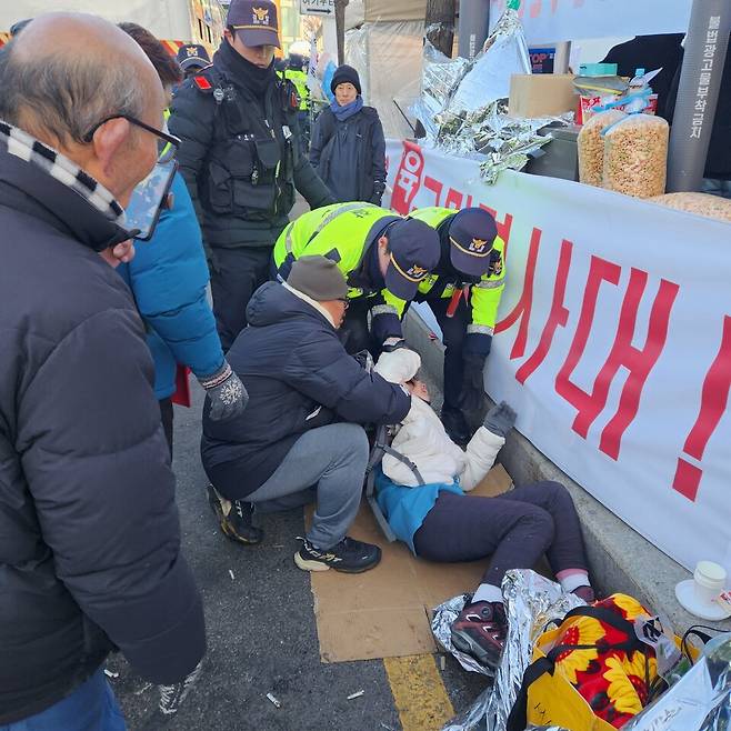 윤석열 대통령에 대한 2차 체포영장 집행이 가시화된 15일 오전 서울 용산구 대통령 관저 앞의 모습. 경찰이 윤 대통령 탄핵 반대를 주장하는 시민이 넘어지자 일으켜 세우려 하고 있다. ⓒ시사저널 이태준