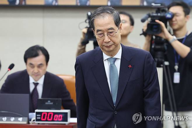 '내란 국조특위' 출석한 한덕수 총리 (서울=연합뉴스) 김주성 기자 = 한덕수 국무총리가 15일 국회 '윤석열 정부의 비상계엄 선포를 통한 내란혐의 진상규명 국정조사' 특별위원회에 기관 증인으로 출석해 안규백 위원장에게 선서문을 전달한 뒤 자리로 돌아가고 있다. 2025.1.15 utzza@yna.co.kr