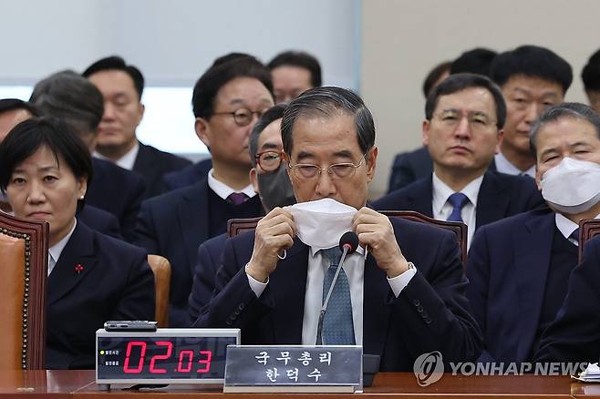 마스크 쓰는 한덕수 총리 (서울=연합뉴스) 김주성 기자 = 한덕수 국무총리가 15일 서울 여의도 국회에서 열린 '윤석열 정부의 비상계엄 선포를 통한 내란 혐의 진상규명 국정조사 특별위원회의'에서 답변 후 마스크를 쓰고 있다. 2025.1.15 utzza@yna.co.kr