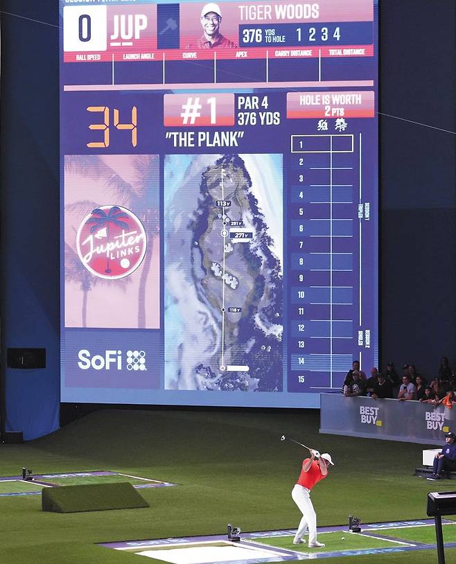 타이거 우즈가 15일 미국 플로리다주 소파이센터에서 열린 TGL 경기에 나서 초대형 스크린을 향해 1번홀 티샷을 하고 있다. /AP 연합뉴스