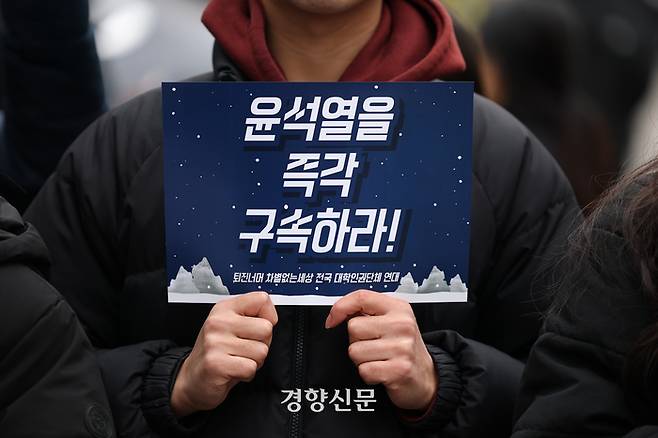 기자회견에 참석한 한 대학생이 윤석열 대통령의 구속을 촉구하는 손팻말을 들고 있다.