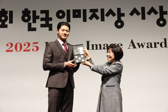 Fencer Oh Sang-uk, left, receives an award from President of Corea Image Communication Institute Choi Jung Hwa, at the Korea Image Awards on Wednesday at Grand InterContinental Seoul Parnas in Gangnam District, southern Seoul. [COREA IMAGE COMMUNICATION INSTITUTE]