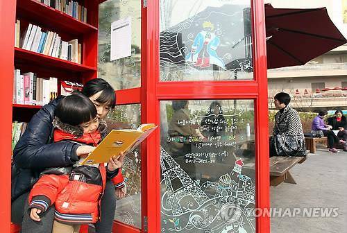 '공중전화부스 안에 책이 있네'  (서울=연합뉴스) 이지은 기자 = 서울 성동구 왕립리역 앞 광장에 위치한 책뜨락에서 한 어린이와 엄마가 책을 보고 있다. 2012.3.7