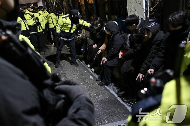 내란 우두머리 혐의로 체포된 윤석열 대통령의 영장실질심사가 열린 18일 오후 서울 마포구 서울서부지방법원에서 윤 대통령의 석방을 촉구하며 법원 담장을 넘어 들어온 청년들이 경찰에 붙잡혀 있다.(공동취재) 2025.1.19/뉴스1 ⓒ News1 민경석 기자