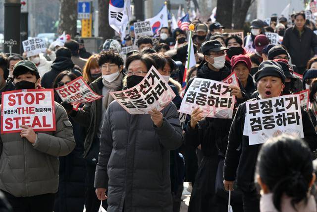 19일 윤석열 대통령 지지자들이 서부지법 인근에서 손팻말을 든 채 서울지하철 3호선 안국역으로 이동하고 있다. 박시몬 기자