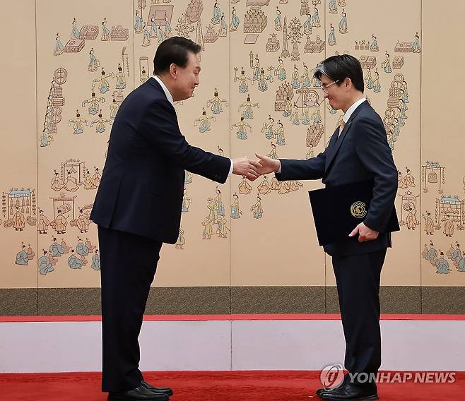 윤석열 대통령, 오동운 공수처장 임명장 수여 윤석열 대통령이 지난해 5월 22일 서울 용산 대통령실 청사에서 열린 고위공직자범죄수사처장 임명장 수여식에서 오동운 공수처장에게 임명장을 수여한 뒤 악수하고 있다.[연합뉴스 자료사진]