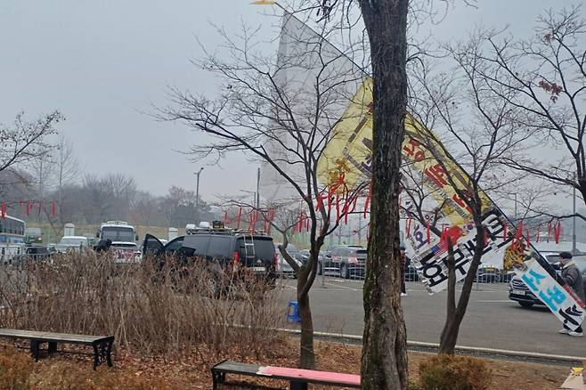 구치소 앞 주차장에 세워진 '이재명 구속'등의 녹음본이 울려퍼지는 스피커 차량과 '탄핵 무효'등이 써붙여진 깃발들 /사진=오석진 기자