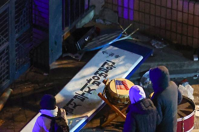 내란 우두머리 혐의를 받는 윤석열 대통령의 구속영장이 발부된 19일 오전 서울 마포구 서울서부지방법원 후문에서 윤 대통령 지지자들이 부순 현판이 놓여 있다. 이들은 이날 오전 3시쯤 윤 대통령 구속영장 발부 소식이 전해지자 극도로 흥분해 법원 후문에서 경찰 저지를 뚫었다. 연합뉴스