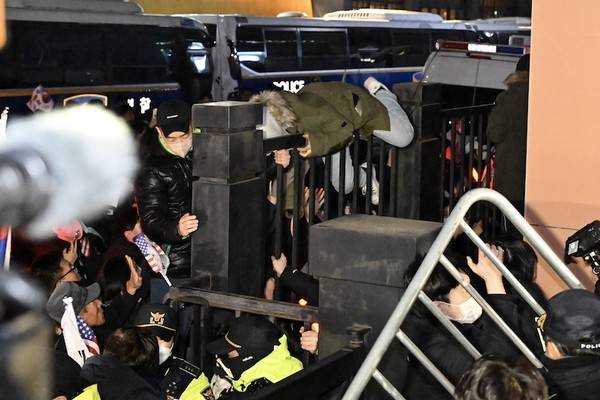 윤석열 대통령 지지자들이 서울 서울서부지방법원의 담장을 넘고 있다. [사진=뉴시스]