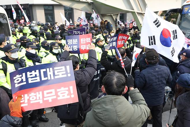 윤석열 대통령의 탄핵심판 3차 변론이 열리는 21일 서울 종로구 헌법재판소 인근에서 윤 대통령 지지자들이 집회를 열고 탄핵 무효를 주장하는 구호를 외치고 있다. 연합뉴스