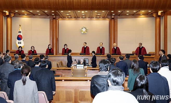 윤석열 대통령이 21일 오후 서울 종로구 헌법재판소 대심판정에서 열린 윤 대통령 탄핵심판 3차 변론기일에 참석했다. 이날 헌법재판관들이 입장하자 참석자들이 기립하고 있다.