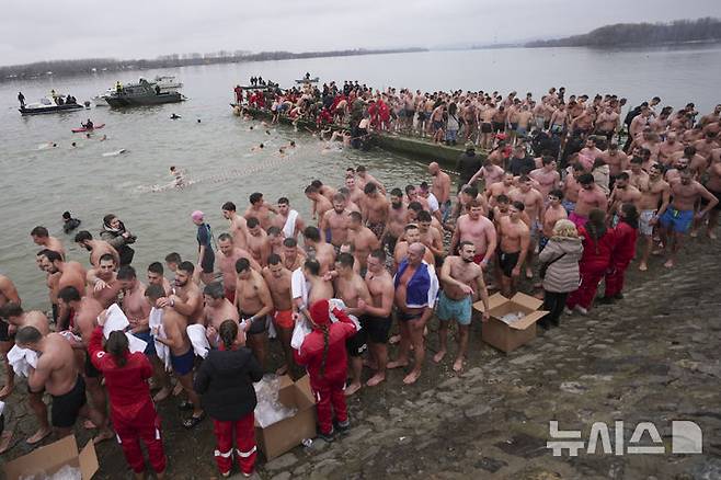 [베오그라드=AP/뉴시스] 19일(현지 시간) 세르비아 베오그라드에서 주현절 기념행사가 열려 십자가를 찾기 위해 다뉴브강에 뛰어들었던 정교회 신자들이 물 밖으로 나와 수건으로 몸을 닦고 있다. 이날 동방 정교회 사제가 물에 던진 나무 십자가를 찾아오는 사람뿐 아니라 이를 찾기 위해 물에 뛰어든 사람 모두가 일 년 내내 건강하게 지낼 수 있다고 믿는다. 2025.01.20.
