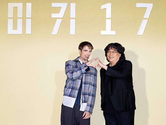 봉준호 감독(오른쪽)과 배우 로버트 패틴슨이 20일 서울 용산구 CGV용산아이파크몰에서 열린 영화 ‘미키 17’ 기자간담회에서 ‘K-하트’ 포즈를 취하고 있다. 연합뉴스