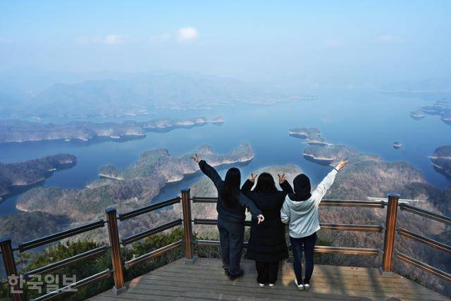 여행객이 충주호가 내려다보이는 악어봉 전망대에서 인증사진을 찍고 있다. 악어떼가 호수로 헤엄치는 듯한 풍광을 보기 위해 위험하게 산을 오르는 이들이 많아, 월악산국립공원에서 지난해 정식으로 등산로를 개설했다.