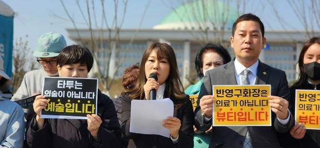 반영구화장·타투·SMP 합법화 비상대책위원회가 지난해 3월13일 국회의사당 앞에서 연 기자회견에서 윤일향(발언자·K뷰티연합회장) 비대위원장이 "의사들은 비의료인의 반영구화장 시술이 무면허 의료행위라고 하지만, 반영구화장은 의료가 아닌 뷰티 영역"이라며 "조속히 합법화해야 한다"고 외치고 있다. /사진=정심교 기자