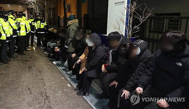 서부지법 무단 침입으로 붙잡힌 윤 대통령 지지자들 (서울=연합뉴스) 서대연 기자 = 내란 우두머리 혐의를 받는 윤석열 대통령의 구속 전 피의자 심문(영장실질심사)이 열린 18일 서울 마포구 서울서부지법에 법원 담장을 넘어 무단 침입한 윤 대통령 지지자들이 경찰에 붙잡혀 있다. 2025.1.18 [공동취재] dwise@yna.co.kr