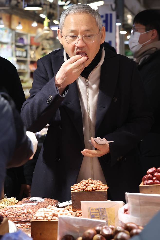 Culture Minister Yu In-chon tries a dried date at Gyeongdong Market in central Seoul on Friday. [MINISTRY OF CULTURE, SPORTS AND TOURISM]