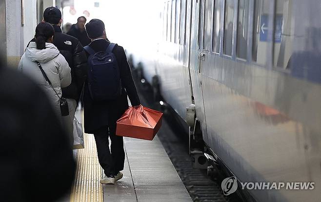 '고향으로' (대구=연합뉴스) 윤관식 기자 = 설 명절 연휴를 하루 앞둔 24일 동대구역에서 귀성객이 선물 세트를 들고 열차를 타기 위해 이동하고 있다. 2025.1.24 psik@yna.co.kr