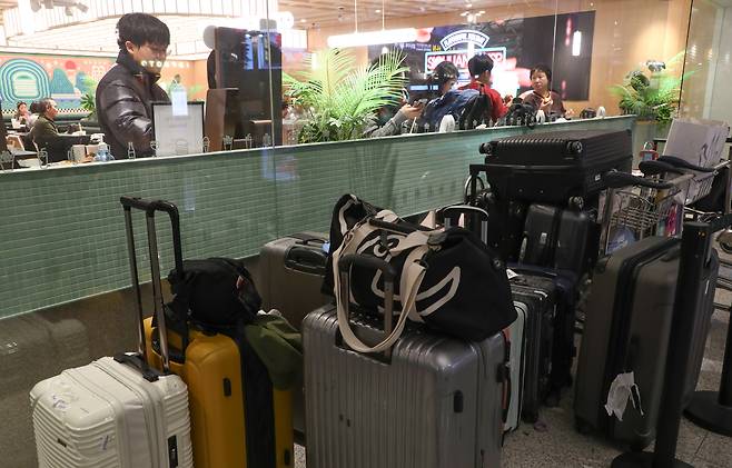 지난 23일 오전 인천국제공항 1터미널에서 아침밥을 먹고 있는 여행객들. 식당 앞에 여행객들의 가방이 놓여 있다. /박성원 기자