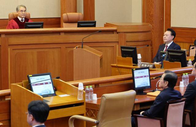 윤석열 대통령이 23일 오후 서울 종로구 헌법재판소 대심판정에서 열린 탄핵심판 4차 변론기일에 출석해 있다. 왼쪽 빈 좌석은 증인석. 사진공동취재단