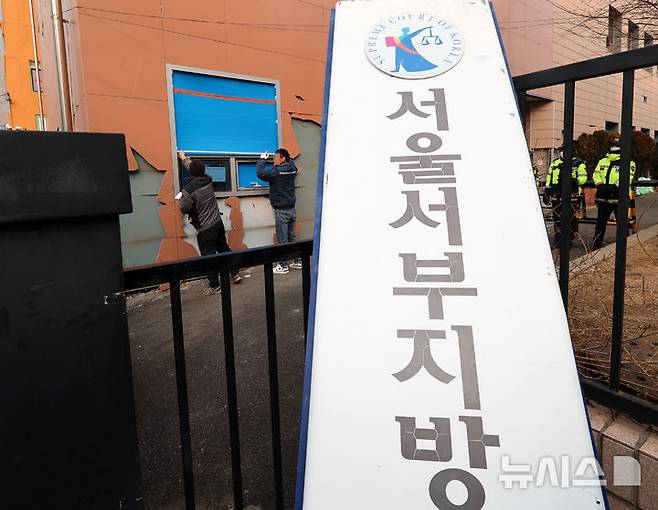 [서울=뉴시스] 이영환 기자 = 20일 오전 서울 마포구 서울서부지방법원에서 공사 관계자들이 파손된 외벽 및 창문 보수작업을 하고 있다.지난 19일 새벽 윤석열 대통령의 구속영장 발부에 지지자들이 집단 폭력 및 법원 안으로 침입하는 사고가 발생했다. 한편 서울서부지방법원은 법원은 정상적으로 운영될 것이라고 밝혔다. 다만 차량을 통한 출입은 불가능하고 출입자는 신분 확인이 필요하다고 전했다.  2025.01.20. 20hwan@newsis.com