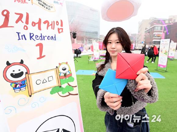 26일 오후 서울 마포구 홍대 레드로드 R1존 에어돔에서 '홍대 에어돔 K-유니버스 페스티벌'이 진행된 가운데 참가자가 오징어게임 딱지치기 체험을 하고 있다. [사진=정소희 기자]
