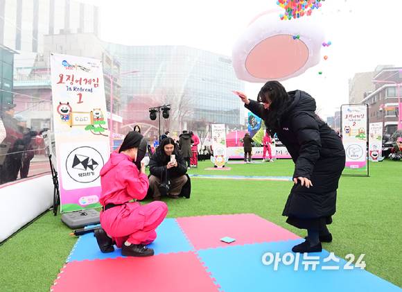 26일 오후 서울 마포구 홍대 레드로드 R1존 에어돔에서 '홍대 에어돔 K-유니버스 페스티벌'이 진행된 가운데 참가자가 오징어게임 딱지치기를 체험 하고 있다. [사진=정소희 기자]