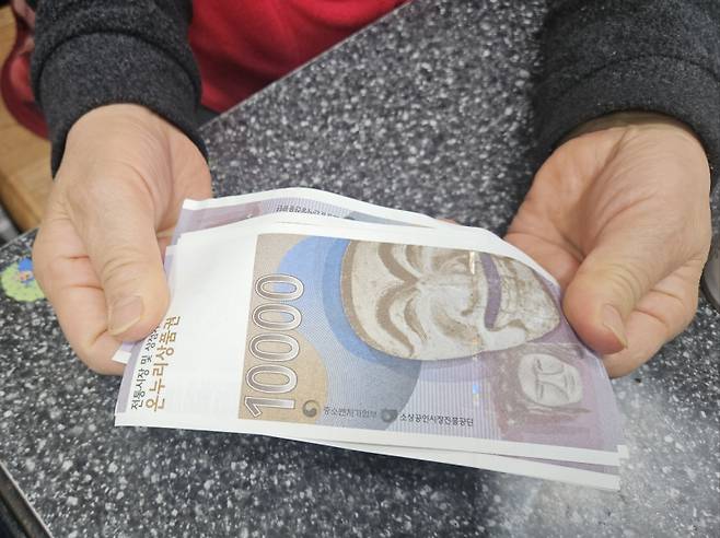 22일 영등포전통시장 한 상점에서 김 모(70세·여)씨가 지류형 온누리상품권을 보여주고 있다. 이우중 기자