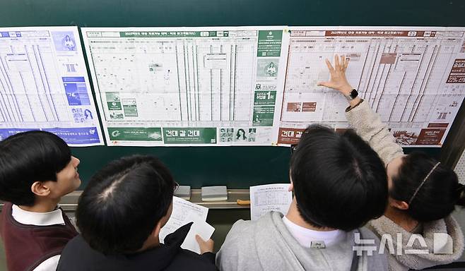 [수원=뉴시스] 2025학년도 대학수학능력시험 성적표가 배부된 지난해 12월6일 경기도 수원시 효원고등학교 3학년 교실에서 수험생들이 전국대학 지원 참고표를 살펴보고 있다. 2025.01.26. jtk@newsis.com