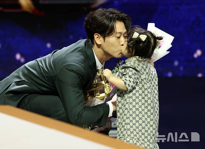 [서울=뉴시스] 이영환 기자 = KIA 타이거즈 박찬호가 13일 오후 서울 강남구 코엑스 오디토리움에서 열린 2024 KBO 골든글러브 시상식에서 유격수 부문 골든글러브를 수상한 후 딸과 뽀뽀를 하고 있다. 2024.12.13. 20hwan@newsis.com