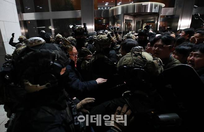 계엄이 선포된 지난달 4일 서울 여의도 국회의사당 본청 입구에서 국회 관계자들이 군인들의 출입을 몸으로 막고 있다. (사진=노진환 기자)