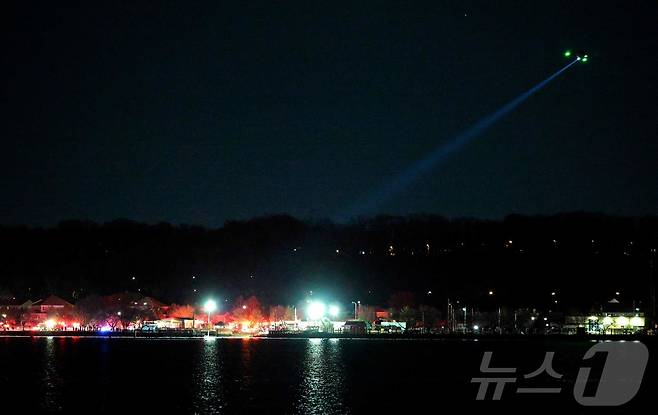 29일(현지시간) 버지니아주 알링턴의 로널드 레이건 공항 인근 포토맥 강에 있는 캐피털 코브 해역에서 헬기가 수색 및 구조 작업을 지원하고 있다. ⓒ AFP=뉴스1 ⓒ News1 류정민 특파원