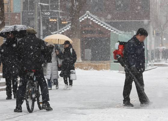 31일 오후 서울 광화문 인근 도로에서 시민들이 우산을 쓰고 이동하고 있다. 연합뉴스