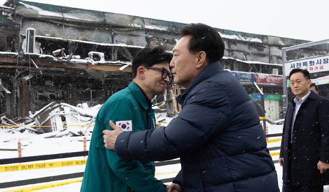 윤석열 대통령이 2024년 1월 23일 오후 충남 서천군 서천수산물특화시장 화재 현장을 찾아 한동훈 당시 국민의힘 비상대책위원장을 만나 악수하고 있다. 김건희 여사 명품 가방 수수건 사과 문제를 놓고 두 사람 사이 갈등이 빚어졌다가 이 만남으로 봉합됐다. [대통령실]