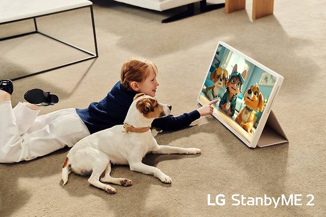 모델이 전용 액세서리를 활용해 LG 스탠바이미 2를 태블릿처럼 세워두고 사용하는 모습. <LG전자>