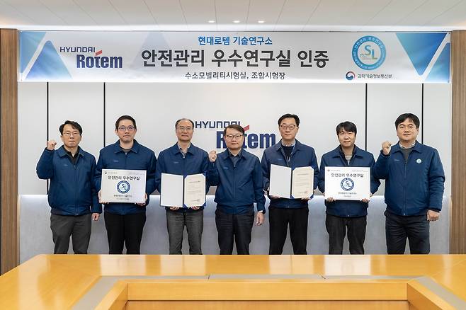 정부 안전관리 우수연구실 인증을 받은 현대로템 관계자들이 지난달 24일 경기 의왕시 본사에서 우수연구실 명판과 인증서를 들고 기념촬영을 하고 있다.  [현대로템 제공]