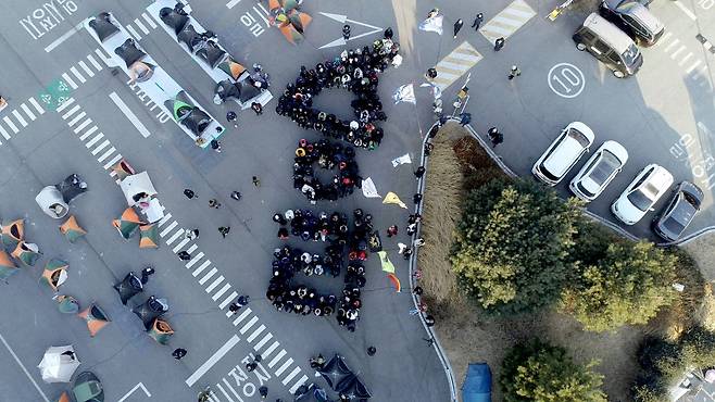 1월11일 한국옵티칼지회의 복직 투쟁에 연대하는 ‘1박2일 희망텐트촌’ 참가자들이 ‘승리’라는 글자를 만들어 고공 농성 중인 노동자들을 응원했다. ⓒ한국옵티칼하이테크지회 제공