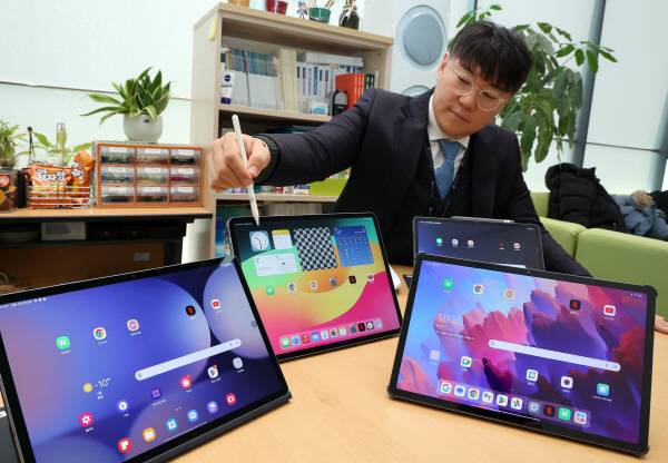 한국소비자원 관계자가 4일 정부세종청사 공정위 기자실에서 태블릿 PC 4개 제품의 시험 평가 결과를 공개하며 해당 제품들을 살펴보고 있다. 연합뉴스