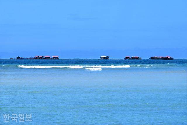 빈탄 섬 동쪽 해안 수평선 부근에 아른거리는 전통 수상가옥 켈롱. 현재는 관광객을 위한 수상레저 거점으로 주로 활용되고 있다.