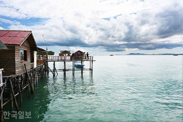 빈탄섬 수상가옥에서 여행객이 낚시를 즐기고 있다.